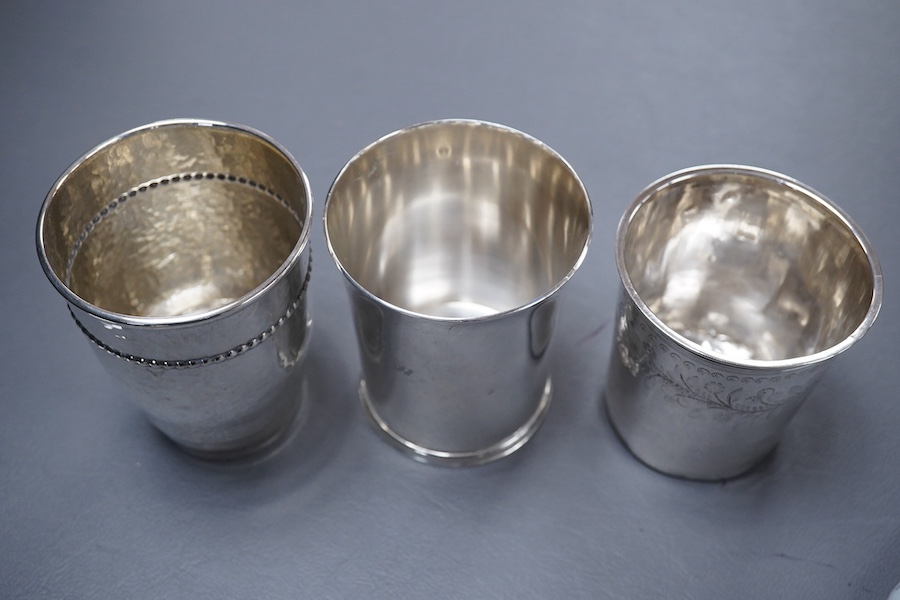 An Elizabeth II silver beaker, with engraved initials, makers TW over BD, London, 1992, 87mm, together with a 1920's hammered Danish white metal beaker and a 19th century French 950 standard white meal beaker, 9.8oz.